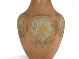 un vase brun posé sur une surface blanche