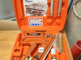 une mallette orange contenant des outils, posée sur une table