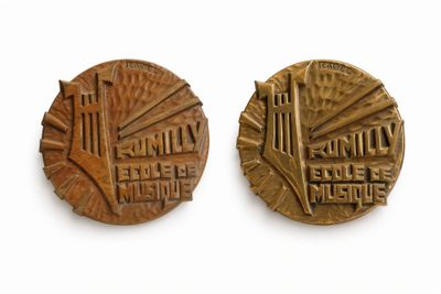 two bronze medals depicting a city and a bridge