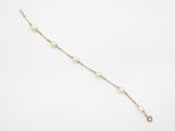 un bracelet en or et perles orné d'une petite breloque en forme de perle
