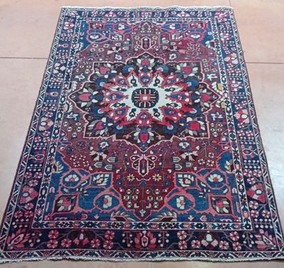 un vieux tapis persan posé à même le sol dans une pièce