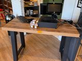 une table en bois sur laquelle est posé un ordinateur portable, dans une pièce