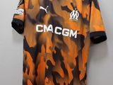 camo shirt with the name of the club on it