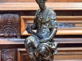 une statue d'un homme assis sur une table