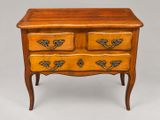 a wooden chest of drawers with brass handles and drawers