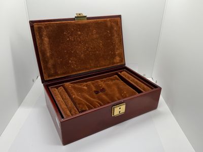 une vieille boîte en bois doublée de velours, posée sur une surface blanche