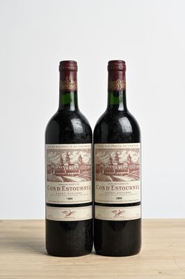 two bottles of wine sitting on top of a wooden table next to each other