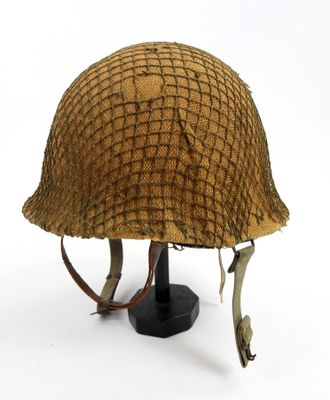 an old helmet on a black stand on a white background