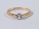 a yellow gold ring with a white diamond in the center