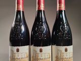three bottles of red wine sitting on top of a table