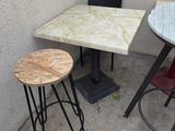 a small table and two stools on the patio