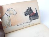 someone is holding a book with a drawing of two dogs on it
