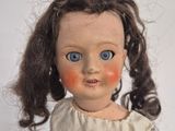 a close up of a doll with a red spot on it ' s face