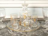 bottles and glasses on a tray on a table in front of a window