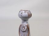 une petite figurine en céramique représentant une femme avec un chat sur l'épaule