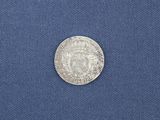 a close up of a silver coin on a blue cloth