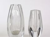 trois vases en verre posés l'un à côté de l'autre sur une surface blanche