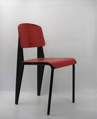 the chair is made of wood and has a red leather seat