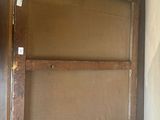 a wooden cabinet with a glass door on top of it