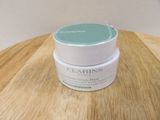 a jar of clarins cream on a wooden table