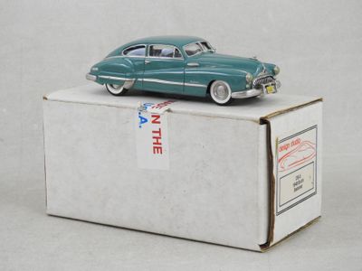 une petite voiture verte posée sur une boîte
