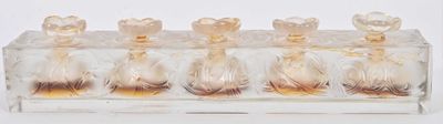 five glass vases in a clear holder on a white surface