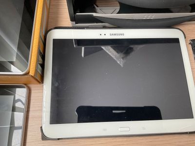 une tablette posée sur une table à côté d'autres appareils électroniques
