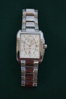 wrist watch on a green surface with a black background