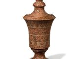 a small vase with a lid sitting on a white surface