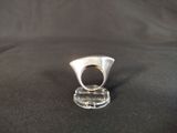 sterling silver ring on clear acrylic stand on black cloth