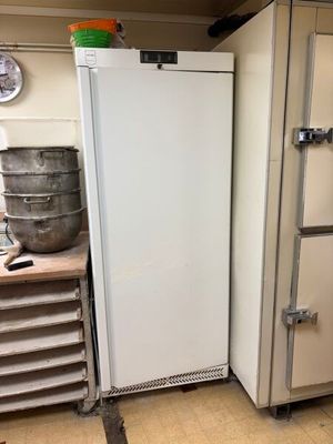 a white refrigerator in a kitchen next to other appliances