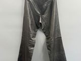 un pantalon en cuir suspendu à un cintre devant un mur blanc