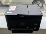 a printer sitting on a window sill in front of a car