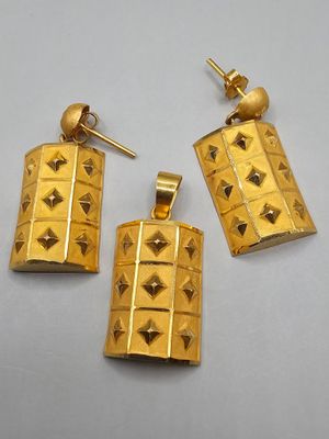 a pair of gold earrings with pyramids on them