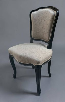 une chaise noire et blanche dont l'assise est rembourrée de couleur beige