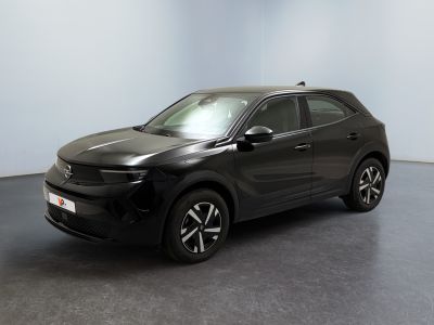 Une voiture noire est garée dans une pièce au sol gris.