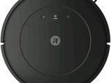 a black robot vacuum cleaner on a white surface