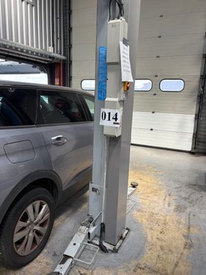 une voiture garée dans un garage équipé d'un pont élévateur