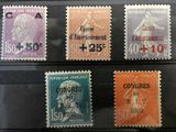 quatre timbres différents, de couleurs et de tailles variées, sur un fond noir