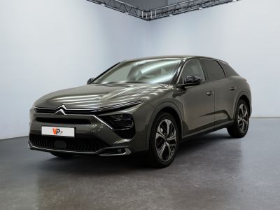 a grey car parked in a large room with a white wall