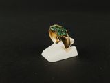 Gros plan sur une bague en or ornée d'une pierre verte