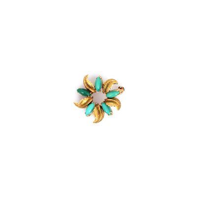 a close up of a gold and green broochle on a white background