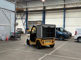 a small yellow vehicle parked in a parking lot