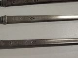 three wrenches sitting on a white surface next to each other