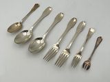 six silver spoons and two silver spoons on a white surface