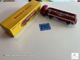 un camion de pompiers en jouet et une boîte posés sur une table