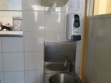 un évier en acier inoxydable dans le coin d'une toilette publique