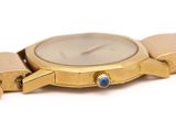 a close up of a gold watch with a blue face