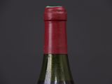 a close up of a bottle of wine with a red cap