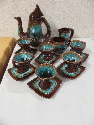 many pieces of pottery sitting on a white table